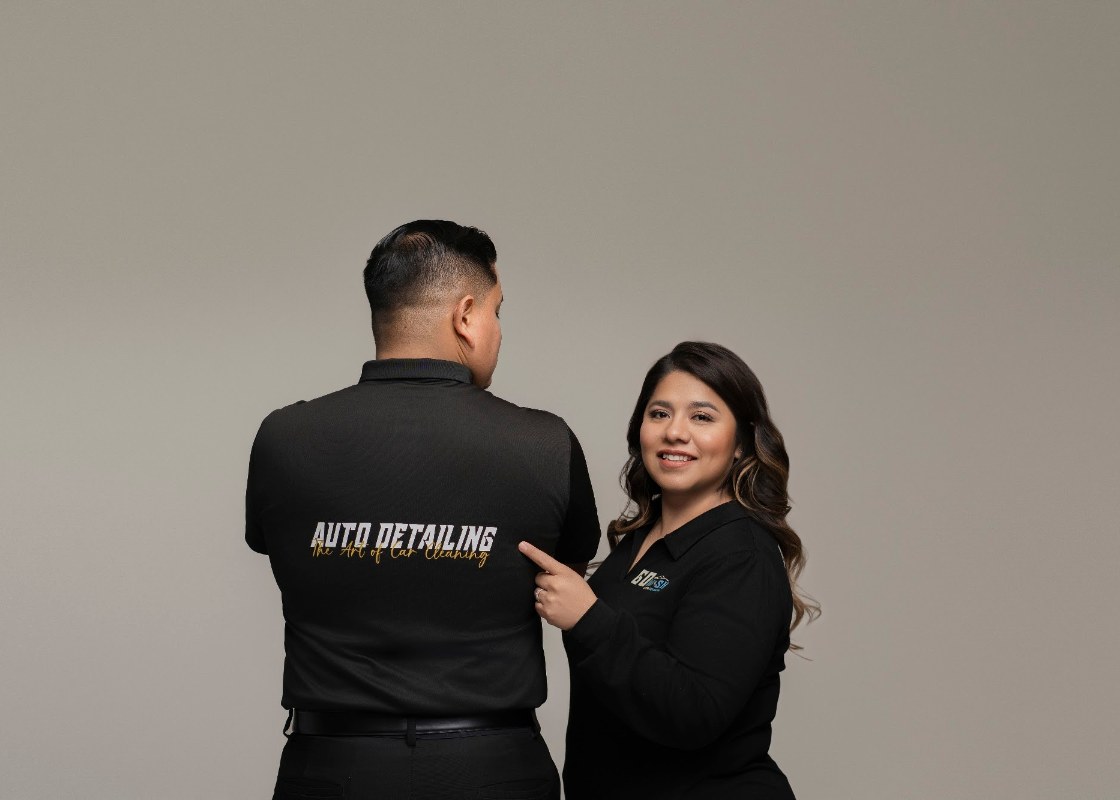 Cinthya Ángeles señalando el logo de Go Wash Auto Detailing en el uniforme del equipo