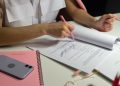 Dos personas revisando documentos y una lista de verificación, los pasos para abrir un negocio en Estados Unidos
