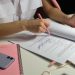 Dos personas revisando documentos y una lista de verificación, los pasos para abrir un negocio en Estados Unidos