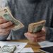 Emprendedor contando dólares de un préstamo para negocios con ITIN
