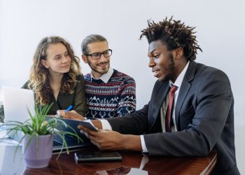Asesor revisa opciones de préstamos SBA con emprendedores hispanos en una reunión de financiamiento