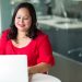 Emprendedora latina sonríe frente a su laptop mientras vende en Amazon con ITIN sin Seguro Social