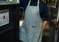 Dueño latino de un food truck con delantal, antes de pagarle a su proveedor y pedirle el formulario W-9