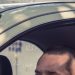 Emprendedor latino manejando su auto de trabajo, deducción con la tarifa por milla del IRS