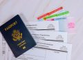 US passport, green card, work permit and USCIS forms on a desk — starting a business without a Social Security number