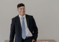 hombre latino dueño de negocio revisando el aviso B del IRS en su oficina