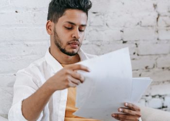 hombre latino revisando la carta de cierre de su EIN tras el Formulario 966
