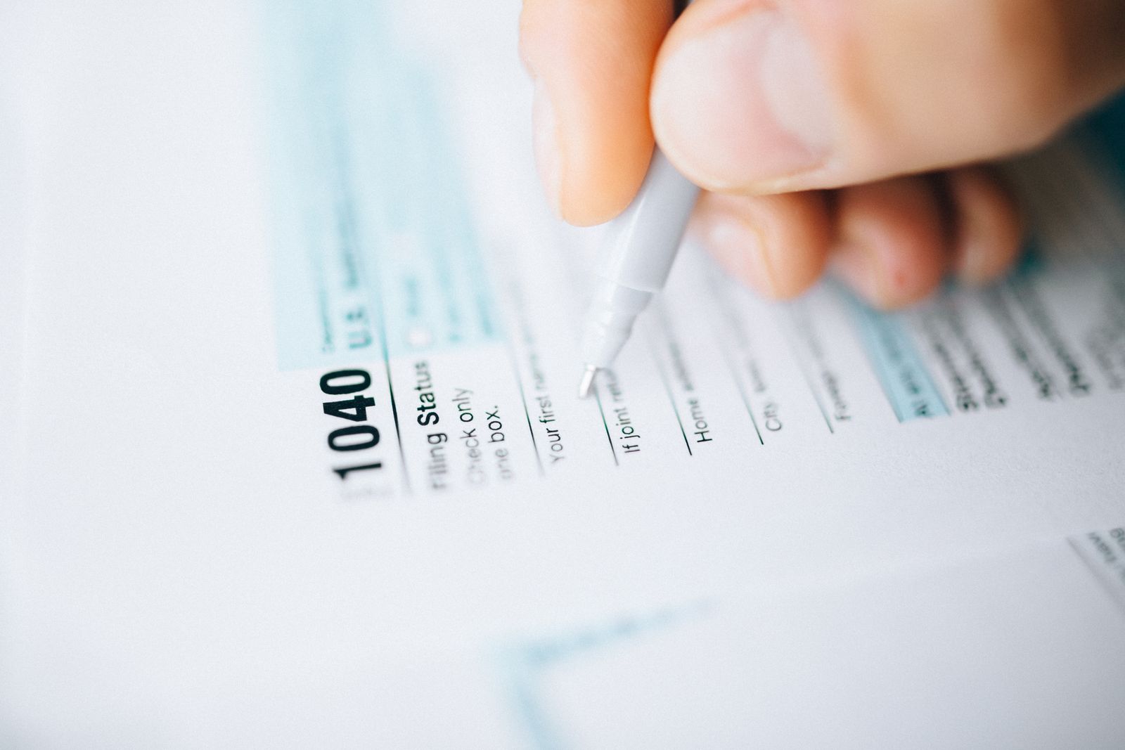 Hand filling out a US tax form with a pen