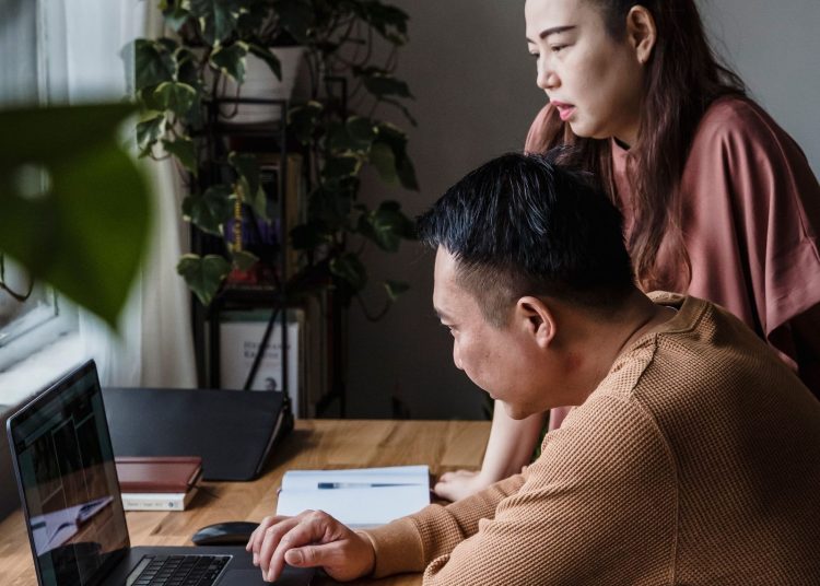 Pareja de dueños de negocio revisando la resolución de disolución de su corporación